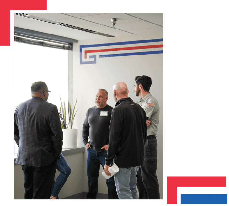 Home-service operators and Flint Group team members talking inside a Flint Group office beneath the company’s red-and-blue wall mark.