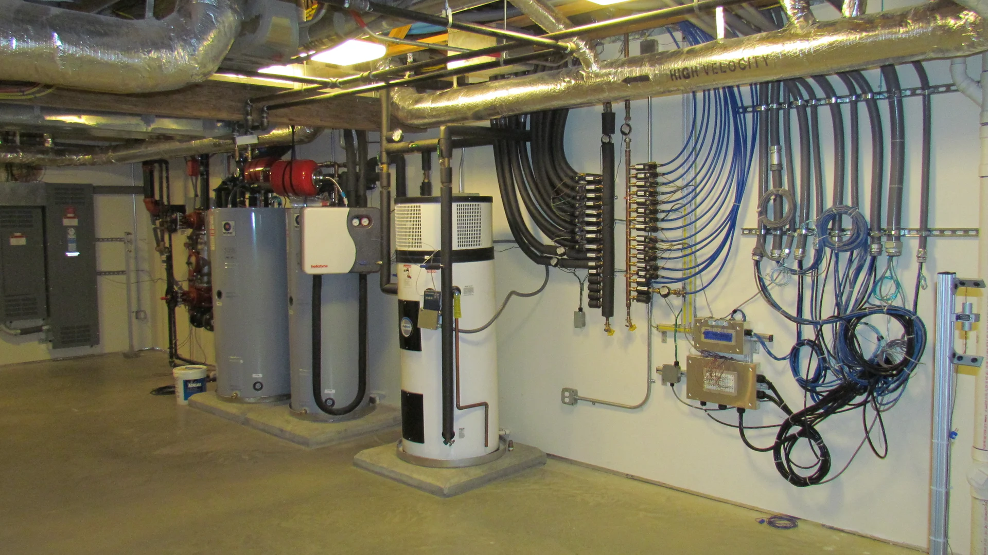 A heat-pump water heater, solar storage tanks and plumbing distribution lines in a NIST residential research-facility basement.