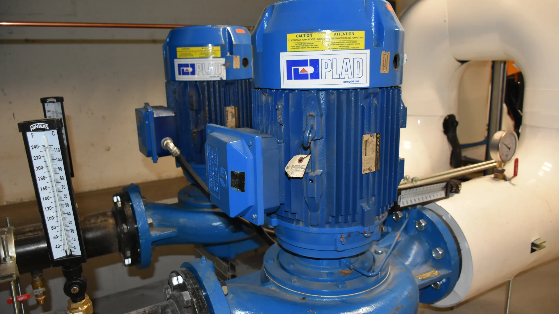 Two centrifugal pumps connected to insulated pipework in a hydronic heating installation.