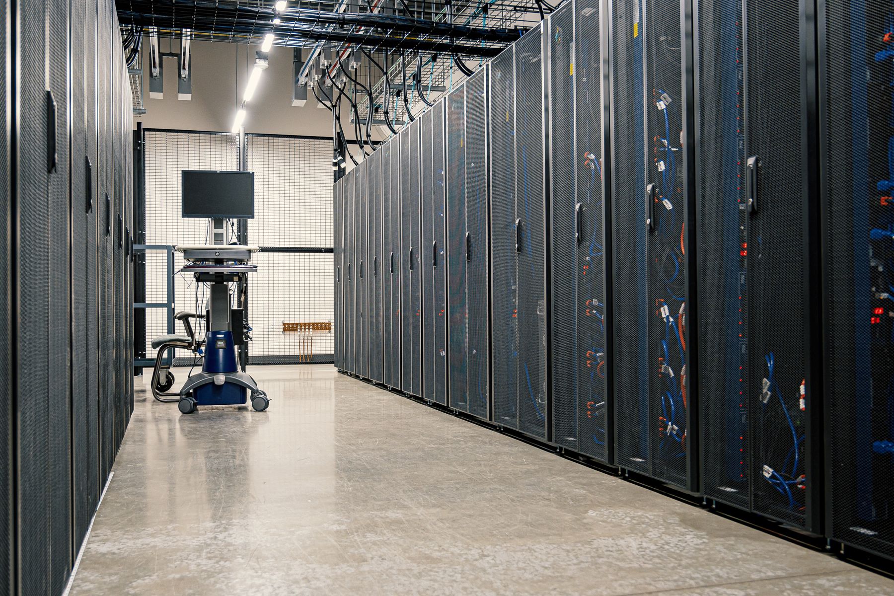 Rows of server racks and connected cabling in a modern data center.