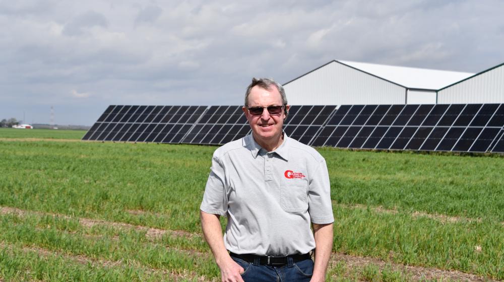 Doug Goyings standing in front of solar panels and farm buildings in northwest Ohio.